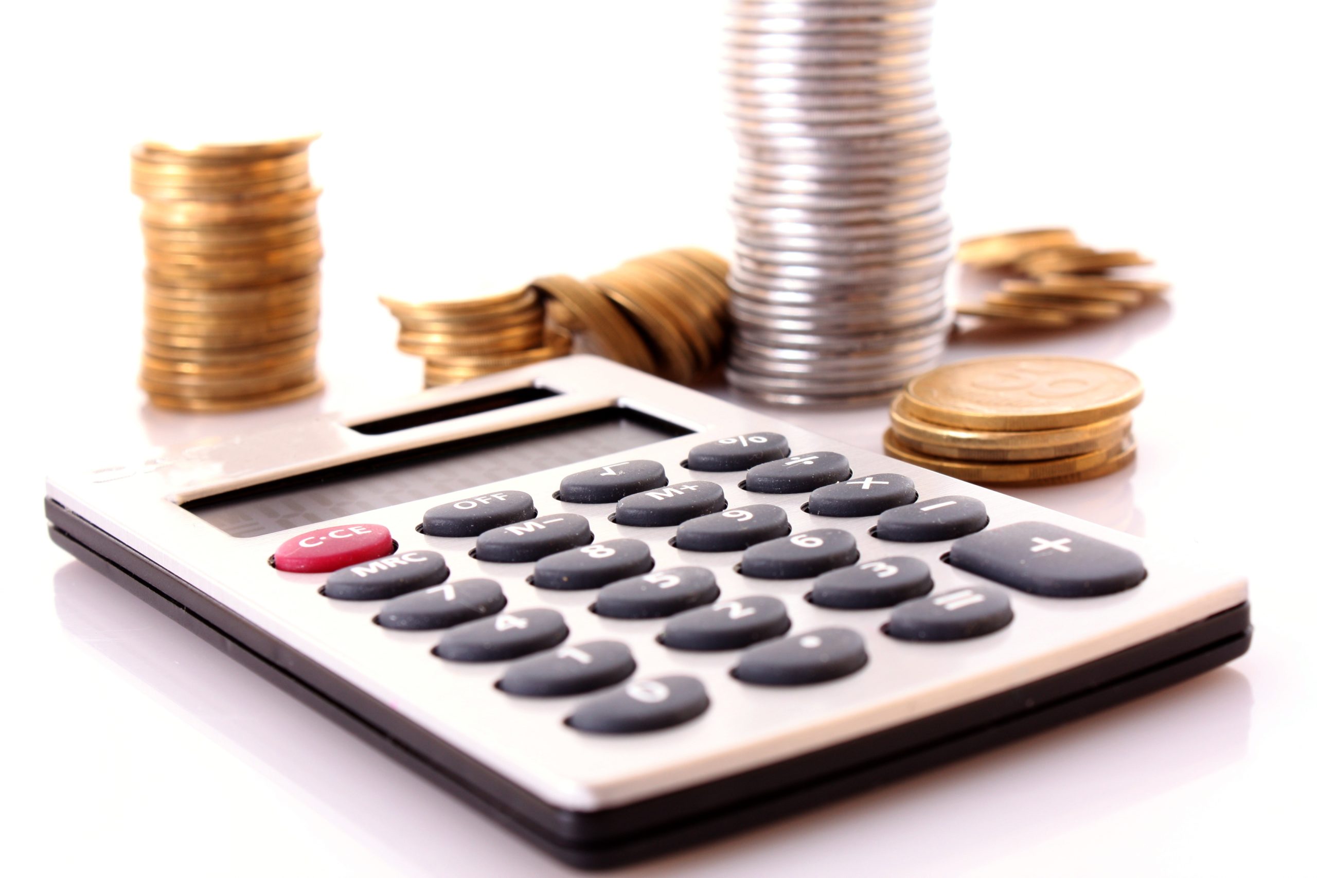 calculator surrounded by coins